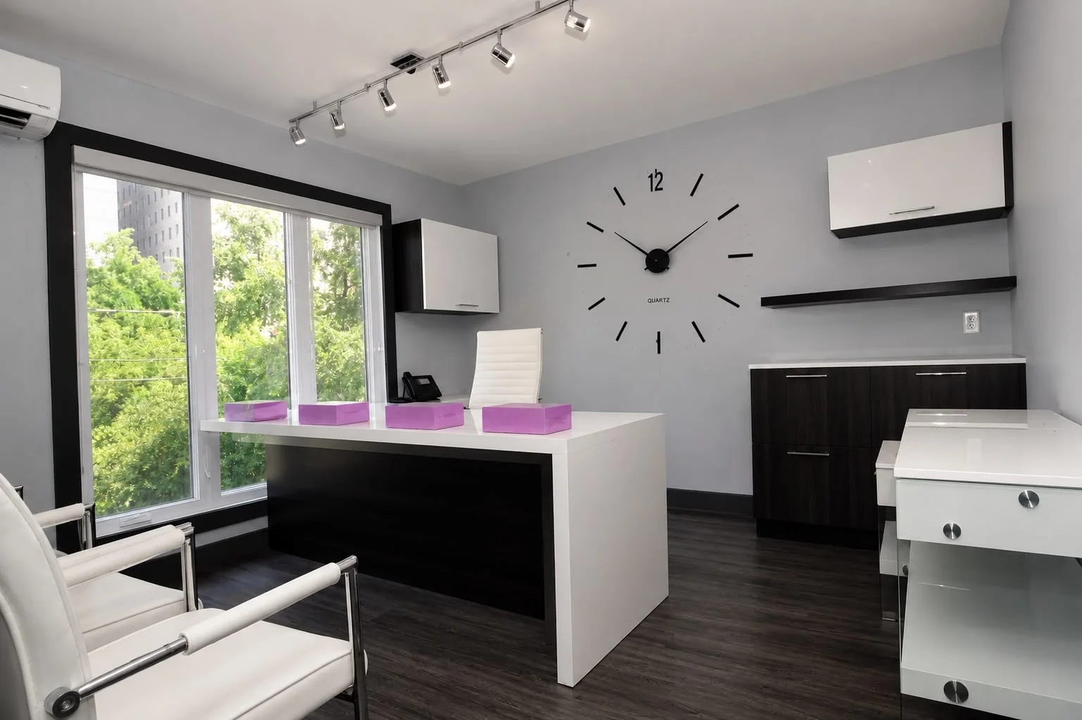 Clean administrative office with a large minimalist wall clock