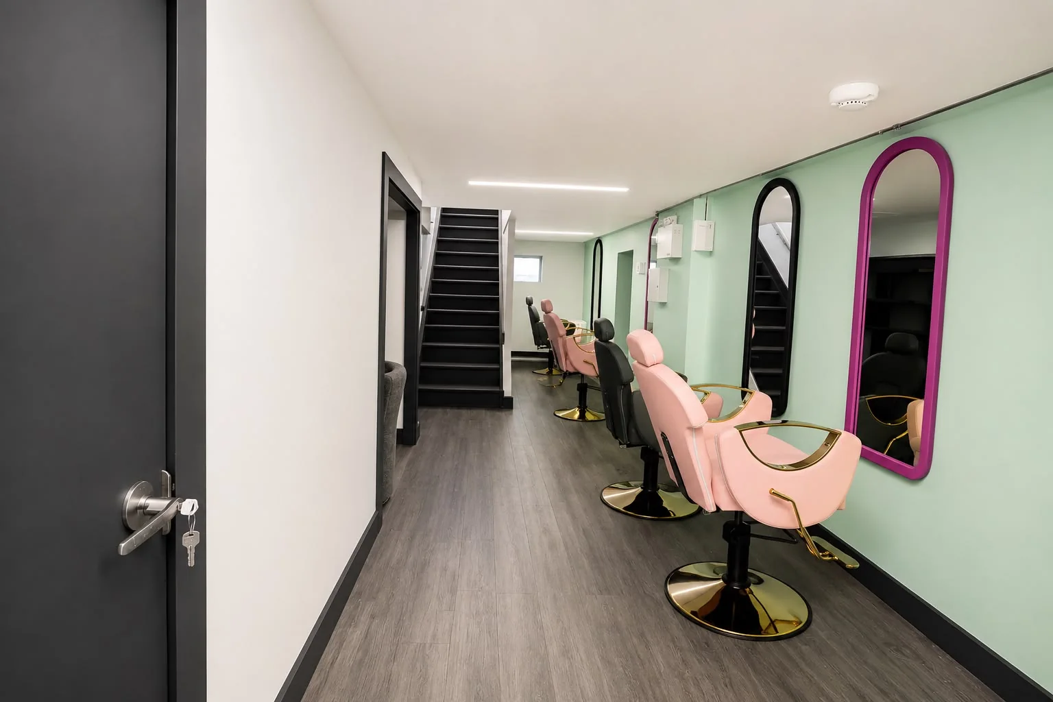 Row of styling stations against a mint wall with colourful mirrors